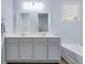 Bathroom with double sinks, tile floors, and bathtub with shower at 9703 Mosgrove Ave, Ladson, SC 29456