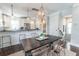 Bright dining area featuring a wooden table with seating, stylish lighting, and a view of the modern kitchen at 975 Warrick Oaks Ln, Mount Pleasant, SC 29464