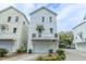 Charming three-story home with a garage, balcony, and landscaped front yard at 975 Warrick Oaks Ln, Mount Pleasant, SC 29464