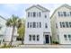 Charming three-story home with white siding, black shutters, and a well-maintained yard at 975 Warrick Oaks Ln, Mount Pleasant, SC 29464