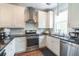 Well-lit kitchen with stainless steel appliances, white cabinets, and black countertops at 975 Warrick Oaks Ln, Mount Pleasant, SC 29464