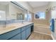 Bathroom featuring double sinks, an expansive mirror, and tub at 1 Battery Park Rd, Edisto Island, SC 29438