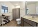 Bright bathroom with shower-tub, wood-look flooring, updated vanity, decorative mirror, and storage shelf at 1 Battery Park Rd, Edisto Island, SC 29438