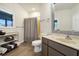 Bright bathroom with shower-tub, wood-look flooring, updated vanity, decorative mirror, and window at 1 Battery Park Rd, Edisto Island, SC 29438