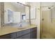 Updated bathroom vanity with decorative mirror, quartz counters, and gold-framed glass shower at 1 Battery Park Rd, Edisto Island, SC 29438