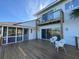 Two story home with deck and sliding glass doors, a screened in porch and outdoor chairs at 1 Battery Park Rd, Edisto Island, SC 29438