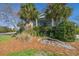 Well-maintained home showcasing manicured landscaping, mature trees, and a charming rock garden feature at 1 Battery Park Rd, Edisto Island, SC 29438