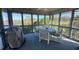 Enclosed porch with large windows, table, chairs and views of water and trees at 1 Battery Park Rd, Edisto Island, SC 29438