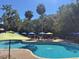 Inviting swimming pool area with sun loungers and umbrellas, surrounded by lush palm trees at 1 Battery Park Rd, Edisto Island, SC 29438