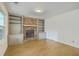 Cozy living room showcasing a brick fireplace, built-in shelving, wood floors and a window for natural light at 107 Lewisfield Dr, North Charleston, SC 29418