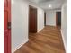 Inviting hallway with hardwood floors, white walls and red door providing a warm and spacious walkway at 1085 Russellville Rd, Saint Stephen, SC 29479