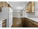 Kitchen leading to a living room with wood floors, featuring wood cabinets and white appliances at 1109 Lee Shore Ln, Mount Pleasant, SC 29464