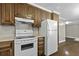 A kitchen features wooden cabinets, a white stove, and a white refrigerator against neutral walls at 1109 Lee Shore Ln, Mount Pleasant, SC 29464