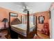 Traditional bedroom with four post bed, ceiling fan, wood floors, and bright orange walls at 1144 Island View Dr, Mount Pleasant, SC 29464