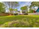 Expansive, grassy backyard featuring a cozy seating area, complemented by mature trees and privacy fencing at 1174 Pittsford Cir, Charleston, SC 29412