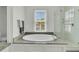 Bright bathroom featuring a soaking tub, glass-enclosed shower, and neutral tile flooring at 12 Leeann Ln, Mount Pleasant, SC 29464