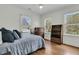 Bright bedroom with hardwood floors, three windows, ceiling fan, blue comforter, and wood bookcase at 12 Leeann Ln, Mount Pleasant, SC 29464