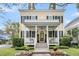 Inviting two-story home featuring a covered porch, black shutters, and beautiful landscaping at 12 Leeann Ln, Mount Pleasant, SC 29464