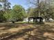 Wide backyard featuring mature trees, green grass, and a pergola beside a charming white house at 130 Oak Crest Dr, Moncks Corner, SC 29461