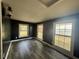Bright bedroom with dark painted walls, stylish flooring, three windows and modern light fixture at 130 Oak Crest Dr, Moncks Corner, SC 29461