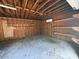Spacious garage featuring exposed rafters, concrete floor, shelving, and convenient climate control at 130 Oak Crest Dr, Moncks Corner, SC 29461