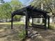 Exterior shot of black pergola in backyard, featuring seating and a charming firepit area at 130 Oak Crest Dr, Moncks Corner, SC 29461