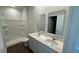 Bathroom with a double vanity, wood-look flooring, and a shower with white walls at 131 River Hill Rd, Goose Creek, SC 29445