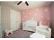 This cheerful Bedroom includes a white crib and chair, rocking horse, and stylish daisy wall decor at 1400 Harbor Mist Ct, Charleston, SC 29492