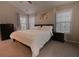 A well lit main bedroom that features a large bed, dresser, and natural light at 1400 Harbor Mist Ct, Charleston, SC 29492