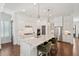 Bright kitchen features white cabinets, marble countertops, stainless steel appliances, and an island with seating at 1479 Mossy Branch Way, Mount Pleasant, SC 29464