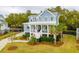 Attractive two-story home with a classic front porch, complemented by palm trees and a well-kept lawn at 1529 Tomato Farm Cir, Mount Pleasant, SC 29464
