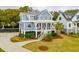 Charming two-story blue home with a welcoming front porch, manicured lawn, and lush landscaping at 1529 Tomato Farm Cir, Mount Pleasant, SC 29464