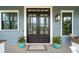 Charming home exterior featuring a stylish double-door entry, sidelight windows, and potted plants at 1529 Tomato Farm Cir, Mount Pleasant, SC 29464