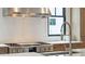 Modern kitchen featuring a stainless steel range hood, gas range, and tile backsplash at 1529 Tomato Farm Cir, Mount Pleasant, SC 29464