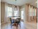 Bright dining area featuring a round wooden table, modern light fixture, and large windows at 158 Garden Lily Ln, Summerville, SC 29485
