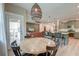 Open-concept dining area showcasing wood table, kitchen island with seating, and view into the living room at 158 Garden Lily Ln, Summerville, SC 29485