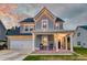 Charming two-story home boasts a welcoming front porch, attached garage, and beautiful curb appeal at 158 Garden Lily Ln, Summerville, SC 29485