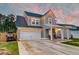 Charming two-story home featuring a two-car garage and a cozy front porch with rocking chairs at 158 Garden Lily Ln, Summerville, SC 29485