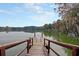 Charming wooden dock extends into a calm lake reflecting the blue sky and trees at 158 Garden Lily Ln, Summerville, SC 29485