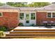 Backyard patio with steps up to the light blue back door of the red brick home with a table and chairs on the patio at 1756 Mchenry Ave, Charleston, SC 29412