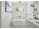 Bright bathroom features a modern soaking tub, a chandelier and a gray vanity at 1756 Mchenry Ave, Charleston, SC 29412