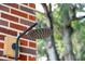 The outdoor shower is mounted to a red brick wall near the green leaves of the trees at 1756 Mchenry Ave, Charleston, SC 29412
