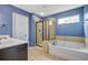 Bathroom featuring a modern glass shower, a separate tub with bronze fixtures, and blue walls at 1909 Royal Empress Ct, Charleston, SC 29414