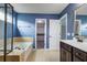 Modern bathroom with a large tub, glass-enclosed shower, sink, and view of a walk-in closet at 1909 Royal Empress Ct, Charleston, SC 29414