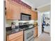 Kitchen featuring stainless steel stove and microwave, light wood cabinets and a pantry at 1984 Folly Rd # A306, Charleston, SC 29412