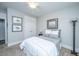A neutral toned bedroom has a window, a lamp, a double bed and framed photos hanging above at 2010 Redback Dr, Summerville, SC 29483