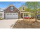 Lovely home with stone and siding, a two-car garage, and a welcoming front porch with chairs at 2010 Redback Dr, Summerville, SC 29483