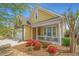 Charming yellow home with a stone garage, inviting front porch and vibrant landscaping at 2010 Redback Dr, Summerville, SC 29483