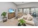 Cozy living room featuring a plush sofa, a wooden cabinet, and beach-themed artwork on the television at 2010 Redback Dr, Summerville, SC 29483