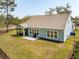 Back exterior of home with screened porch and well-maintained lawn in an aerial view at 2036 Yaupon Way, Johns Island, SC 29455